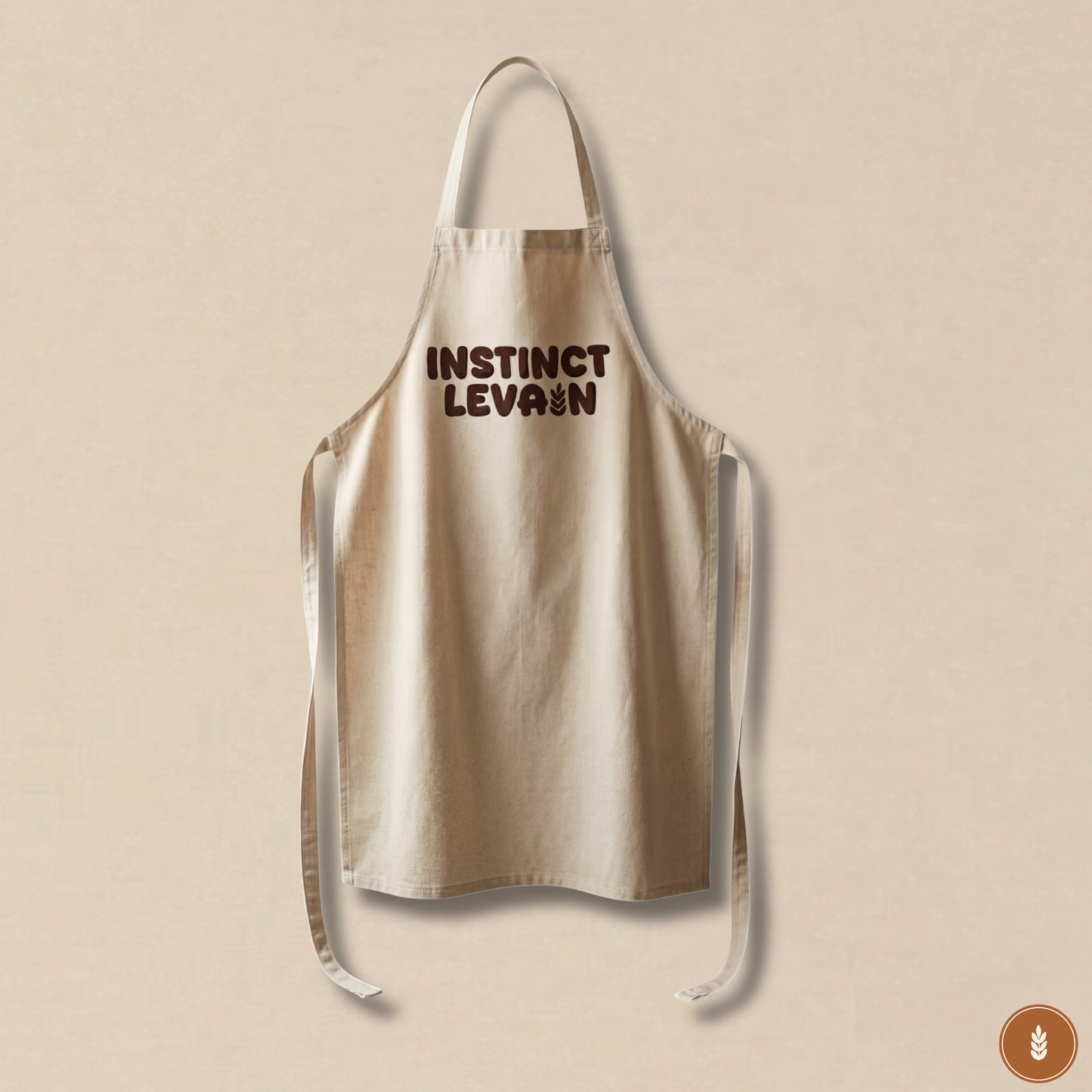 Tablier de cuisine beige Instinct Levain en coton pour boulangerie artisanale et pain maison.